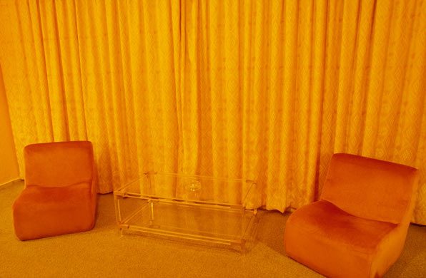 Hotelzimmer mit orangefarbenen Sesseln und Plexiglastisch. © Dominik Reipka professioneller Hotelfotograf Hamburg, Deutschland.