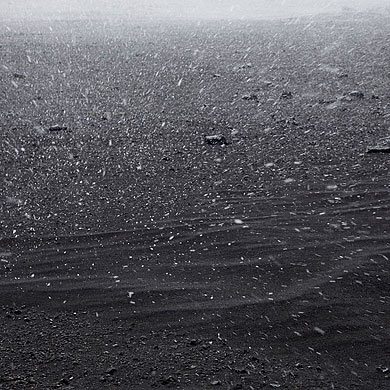Künstlerische Fotografie vom Schneefall auf der schwarzen, vulkanischen Hochebene in Island. © Dominik Reipka Landschaftsfotograf